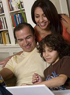 Father, mother and child using a laptop